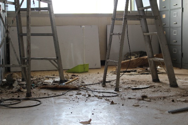 dirty storage unit with two ladders and other junk
